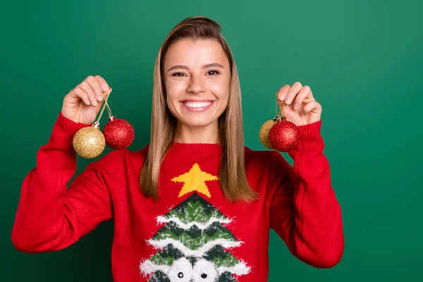 Portret atrakcyjnej wesołej dziewczyny trzymającej w dłoniach kulki festalowe Grudzień Eve Noel tradycja izolowana na zielonym tle — Zdjęcie stockowe