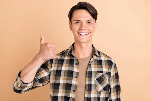 Foto von Millennial funky guy zeigen okey tragen kariertes Hemd isoliert auf beige Hintergrund — Stockfoto