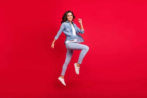 Full length body size view of attractive motivated cheerful girl jumping running isolated over vibrant red color background — Stock Photo, Image