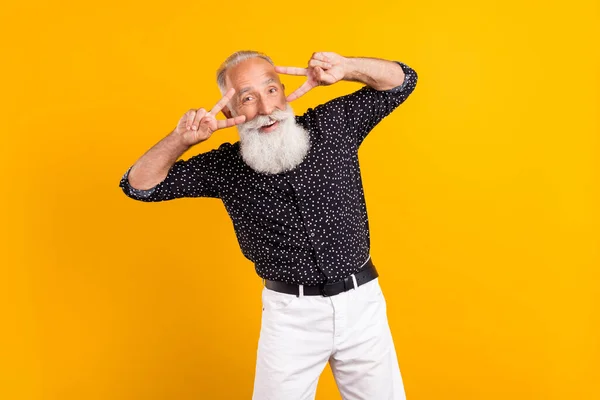 Foto retrato homem vestindo camisa sorrindo dançando na festa mostrando v-sinal isolado vibrante cor amarela fundo — Fotografia de Stock