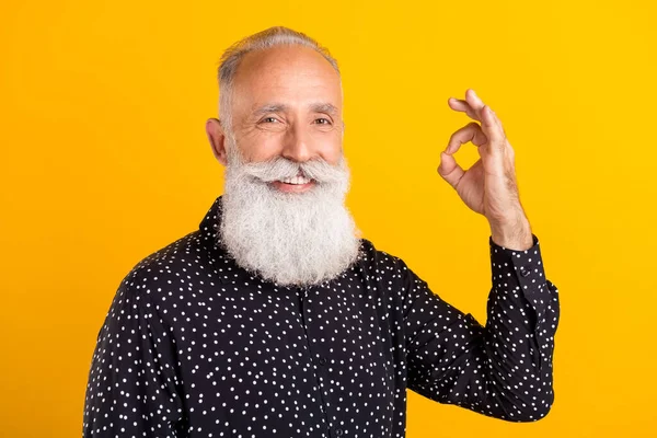 Fotografie veselý šťastný atraktivní starý muž show v pořádku znamení úsměv izolované na žlutém pozadí — Stock fotografie
