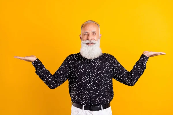 Photo of attractive cheerful positive old man hold hands empty space scales isolated on yellow color background — Stock Photo, Image
