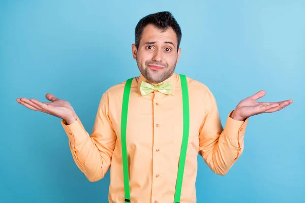 Foto de inseguro morena estranho jovem encolher ombros usar camisa de pêssego isolado no fundo de cor azul — Fotografia de Stock