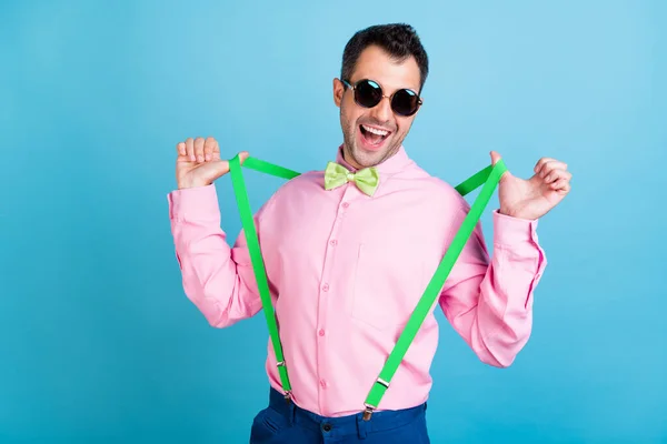 Foto von Phantasie Brunet Frisur Mann berühren Hosenträger tragen Brille rosa Hemd isoliert auf blauem Hintergrund — Stockfoto