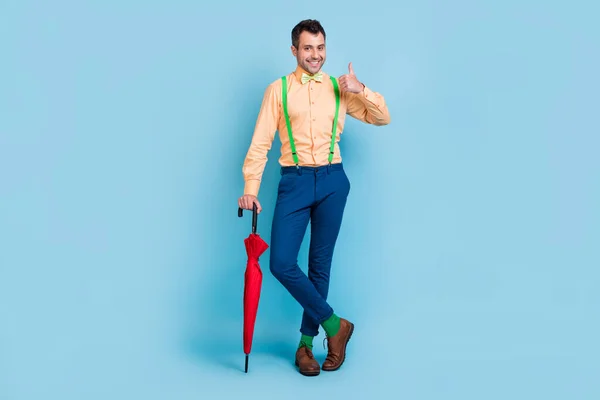 Полная длина фото брюнет мужчина с зонтиком вверх носить рубашку брюки обувь носки изолированы на синем фоне цвета — стоковое фото