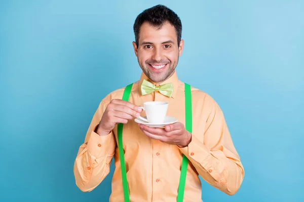 Foto di fresco brunet giovane uomo bere caffè usura pesca camicia isolata su sfondo di colore blu — Foto Stock