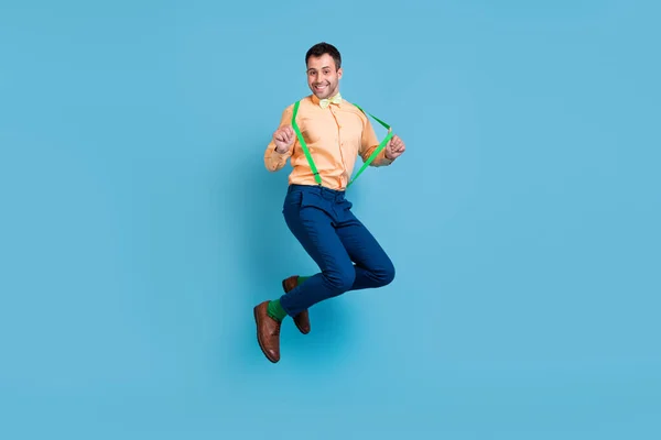 Zdjęcie szalony śmieszne sen facet skok zabawy nosić szelki koszulka muszka izolowane niebieski kolor tło — Zdjęcie stockowe
