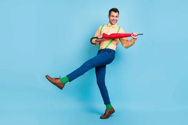 Full body foto van brunet man met parasol dans slijtage shirt broek sokken schoenen geïsoleerd op blauwe kleur achtergrond — Stockfoto