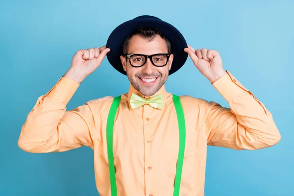 Foto van coole brunet man handen cap dragen brillen perzik shirt bril geïsoleerd op blauwe kleur achtergrond — Stockfoto