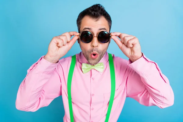 Foto van gek verrast man open mond dragen zonneglas groene bretels shirt strik geïsoleerde blauwe kleur achtergrond — Stockfoto