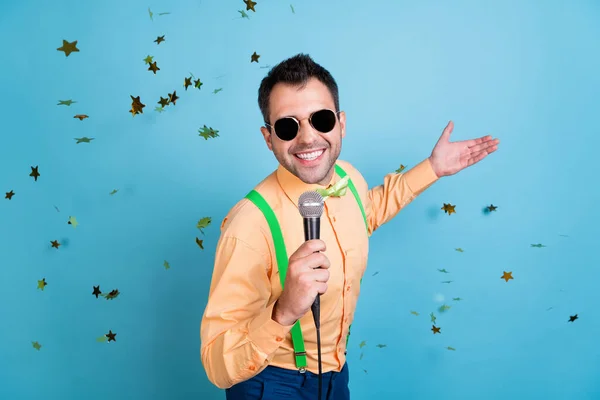 Foto von cool Brunet Mann singen Gespräch in Mikrofon tragen Brille Pfirsichhemd Brille isoliert auf blauem Hintergrund — Stockfoto