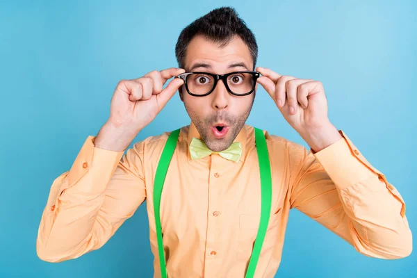 Foto van grappige man omg reactie dragen bril groene bretels shirt strik geïsoleerde blauwe kleur achtergrond — Stockfoto
