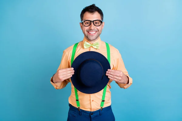 Foto de bom morena jovem segurar boné desgaste óculos pêssego camisa óculos isolados no fundo de cor azul — Fotografia de Stock