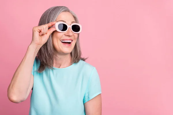 Foto de bela senhora de cabelo branco envelhecido olhar espaço vazio desgaste óculos blusa teal isolado no fundo cor-de-rosa — Fotografia de Stock