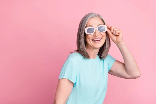 Fénykép lenyűgözött idősebb fehér haj hölgy visel szemüveget teal blúz elszigetelt rózsaszín színű háttér — Stock Fotó