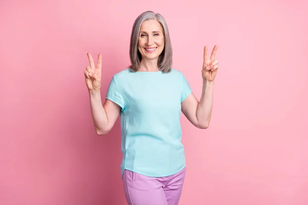 Fénykép a szép öreg szürke frizura hölgy show v-jel viselet kék blúz elszigetelt rózsaszín színű háttér — Stock Fotó