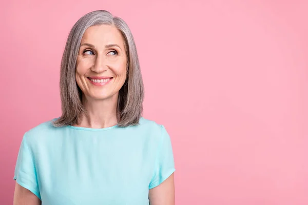 Foto van grappige oude grijze haardos dame kijken lege ruimte dragen blauwe blouse geïsoleerd op roze kleur achtergrond — Stockfoto