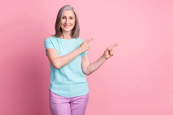 Foto von schönen älteren grauen Frisur Dame Punkt leeren Raum tragen Krickente Bluse isoliert auf rosa Hintergrund — Stockfoto