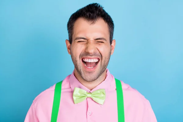 Foto de engraçado animado louco cara desgaste verde suspensórios rosa camisa arco gravata isolado azul cor de fundo — Fotografia de Stock