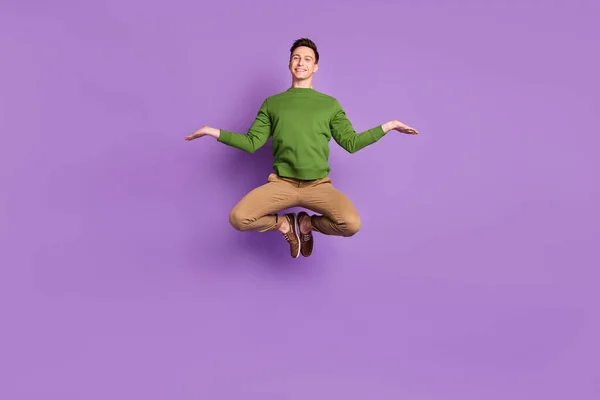 全身写真の若いです面白いですブルネット男ジャンプ着用セーターパンツスニーカー孤立した上の紫の背景 — ストック写真