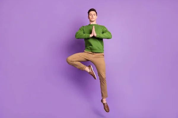 フル長いです写真の千年素敵なブルネット男ジャンプ着用セーターパンツスニーカー隔離された紫色の背景 — ストック写真