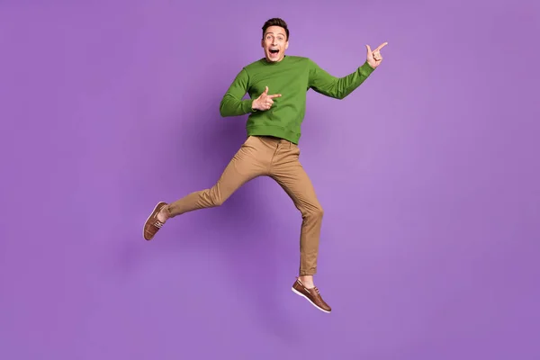 Pełne ciało zdjęcie tysiąclecia wrażenie brunet facet skakać punkt nosić sweter spodnie trampki izolowane na fioletowy tło — Zdjęcie stockowe
