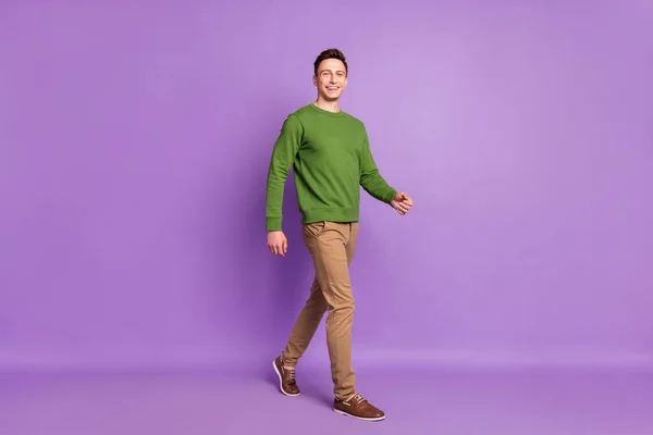 Full size photo of millennial cute brunet guy go wear sweater trousers isolated on purple background — Stock Photo, Image