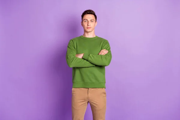 Фото молодого крутого брюнет парень скрещенные руки носить свитер брюки изолированы на фиолетовом фоне — стоковое фото