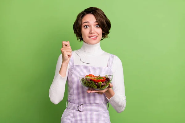 Dudak ısıran fotoğrafçı kadın salata yiyor izole edilmiş pastel rengi arka plan — Stok fotoğraf