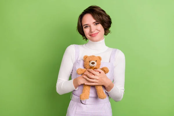 Photo of young attractive girl happy positive smile hug cuddle soft teddy bear toy isolated over green color background — Stock Photo, Image