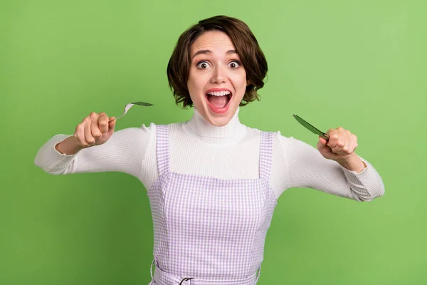 Photo portrait woman keeping fork knife in restaurant crazy hungry isolated pastel green color background — Stock Photo, Image