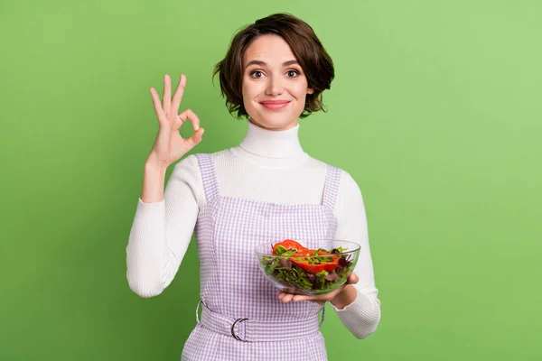 Genç kızın fotoğrafı mutlu pozitif gülümseme sağlıklı sebzeler salata sho tamam reklam işareti yeşil arka plan izole — Stok fotoğraf