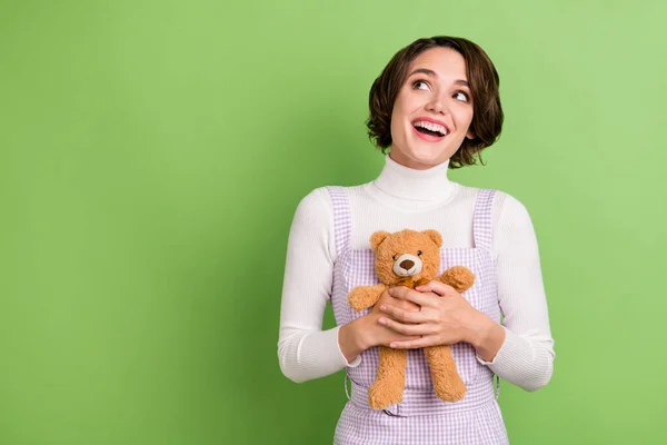 Photo portrait woman keeping soft teddy bear looking blank space dreamy isolated pastel green color background — Stock Photo, Image