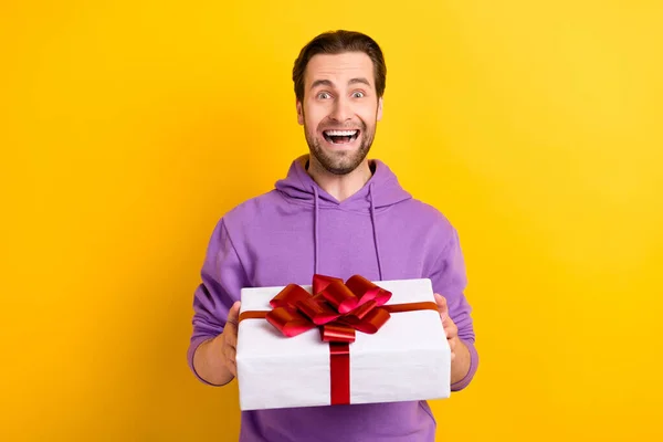 Φωτογραφία του νεαρού ενθουσιασμένοι άνθρωπος χαρούμενος θετικό χαμόγελο πάρει δώρο διακοπές κόμμα απομονώνονται πάνω από κίτρινο χρώμα φόντο — Φωτογραφία Αρχείου