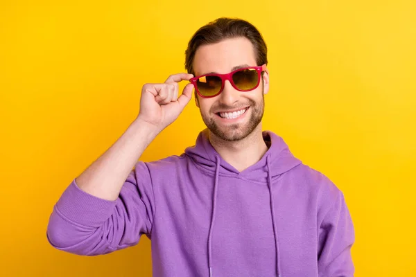 Foto di giovane uomo allegro felice sorriso positivo mano toccare gli occhiali isolati su sfondo di colore giallo — Foto Stock