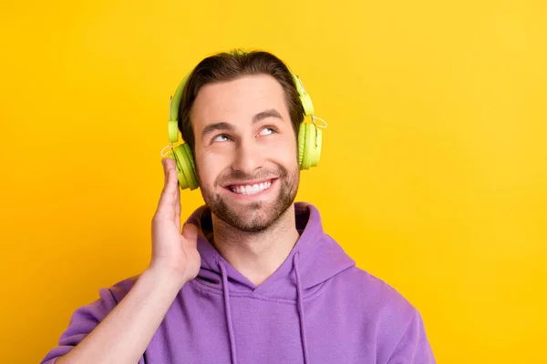Foto van de jongeman blij positieve glimlach droom blik lege ruimte luisteren audio lied geïsoleerd over gele kleur achtergrond — Stockfoto