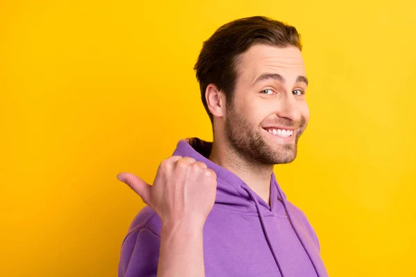 Profil boční fotografie mladého chlapa šťastný pozitivní úsměv bod palec prázdný prostor reklama navrhnout izolované přes žluté barvy pozadí — Stock fotografie