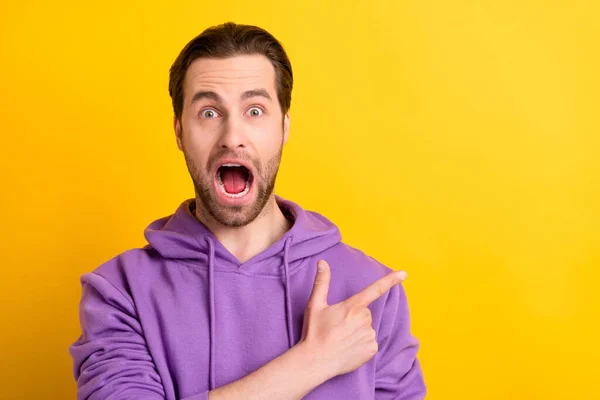 Φωτογραφία του διαφημιστή τύπος δείχνουν δάχτυλο κενό χώρο ουρλιάζουν ανοιχτό στόμα φορούν βιολετί κουκούλα απομονωμένο κίτρινο χρώμα φόντο — Φωτογραφία Αρχείου