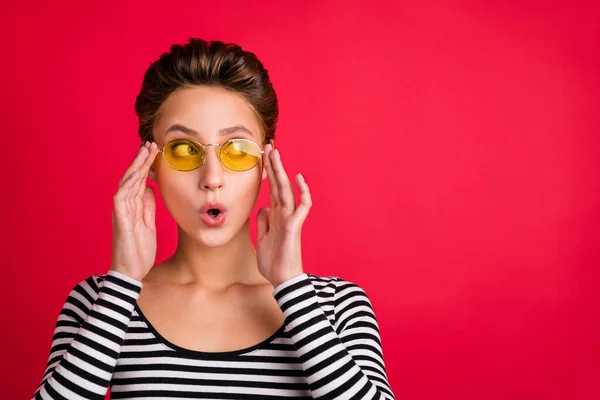 Foto retrato mujer sorprendida usando gafas de sol mirando copyspace aislado vibrante color rojo fondo — Foto de Stock