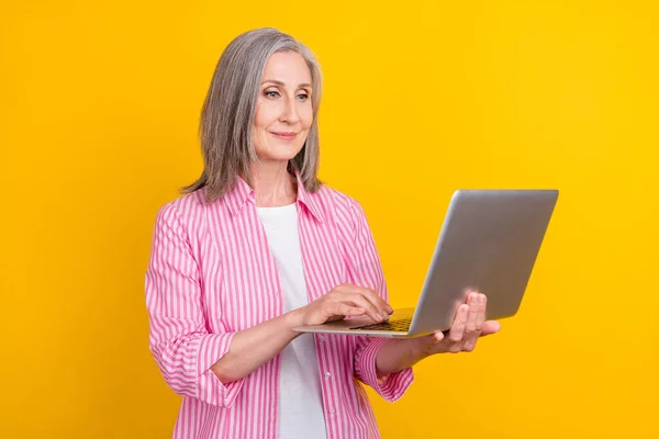 Profilo lato foto di anziana donna d'affari felice sorriso positivo tipo e-mail portatile isolato su sfondo di colore giallo — Foto Stock