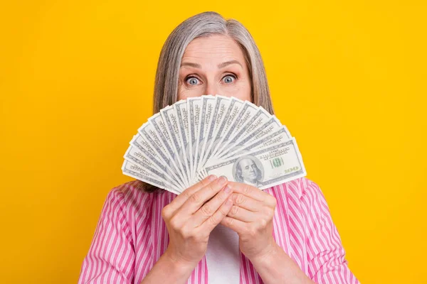 Foto di donna matura felice sorriso positivo chiudere copertina faccia soldi contanti valuta isolato su sfondo di colore giallo — Foto Stock