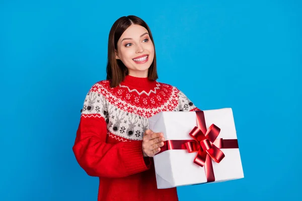 Foto mujer retrato en suéter de Navidad dando regalo en fiesta de año nuevo buscando espacio en blanco aislado vibrante fondo de color azul — Foto de Stock