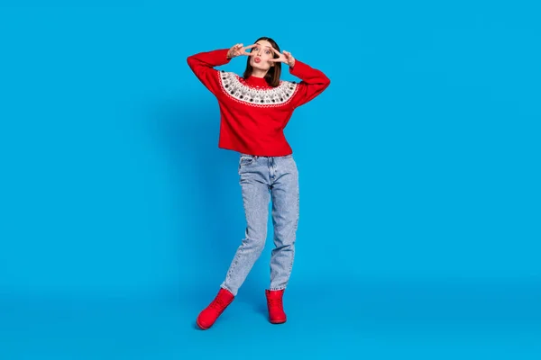 Полная длина тела фото женщина в красном свитере показывая V-знак отправки воздушный поцелуй изолированные ярко синий цвет фона — стоковое фото