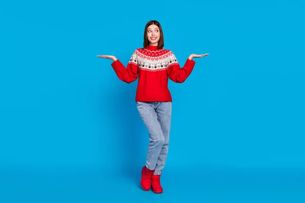 Повна довжина тіла фотографії жінки в червоному пуловері, посміхаючись масштабування порожніх місць на руці ізольовані яскраво-синій колір фону — стокове фото