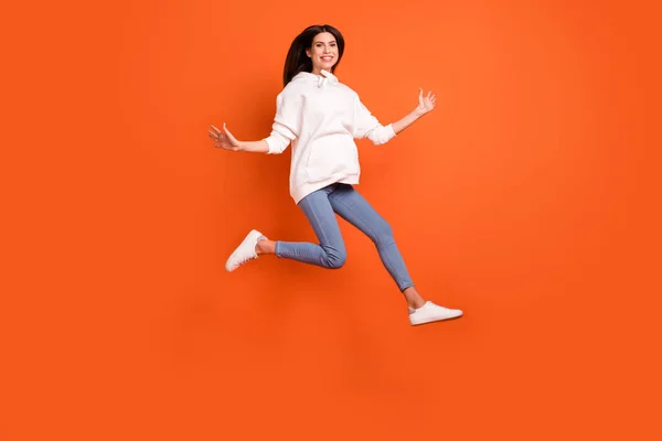 Comprimento total tamanho do corpo vista de menina alegre sorte atraente pulando correndo isolado sobre fundo de cor laranja brilhante — Fotografia de Stock
