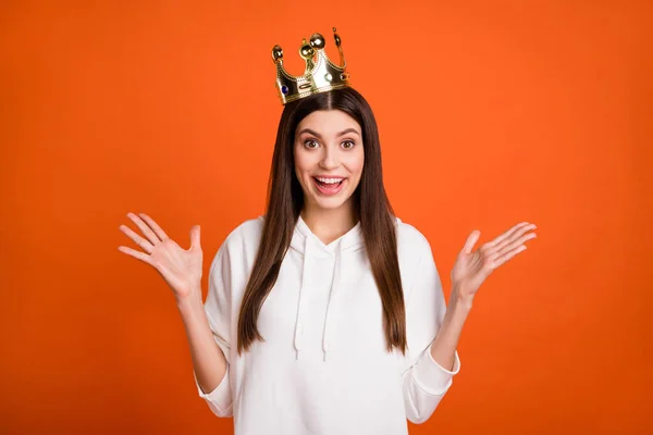 Retrato de chica alegre asombrada atractiva con corona que tiene buen humor divertido aislado sobre fondo de color naranja brillante —  Fotos de Stock