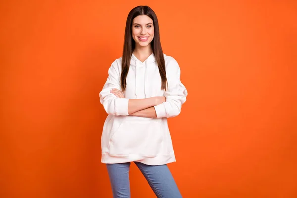 Retrato de atraente alegre morena menina dobrado braços vestindo aconchegante olhar isolado sobre brilhante cor laranja fundo — Fotografia de Stock