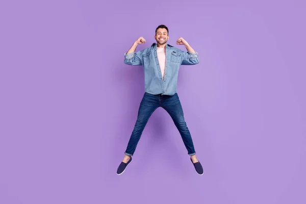 Ganzkörpergröße Foto Mann lächelnd aufspringen zeigt Bizeps isoliert pastellviolette Farbe Hintergrund — Stockfoto
