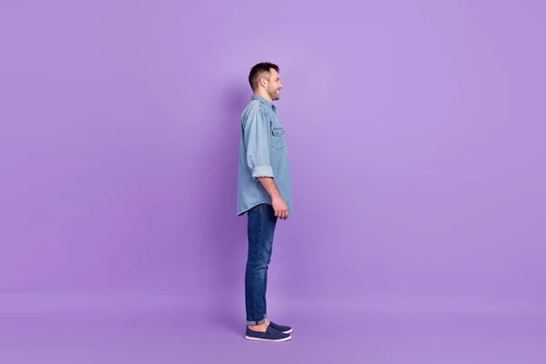 Comprimento total tamanho do corpo foto homem vestindo roupas jeans olhando espaço em branco isolado pastel cor violeta fundo — Fotografia de Stock