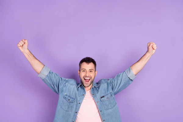 Фотопортрет брюнетка чоловік посміхається жестом, як переможець щасливий, насолоджуючись ізольованим пастельно-фіолетовим кольоровим фоном — стокове фото